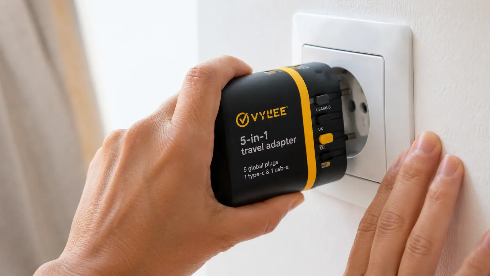 Hand sliding the VYLEE adapter's Type C plug prongs into a European wall outlet